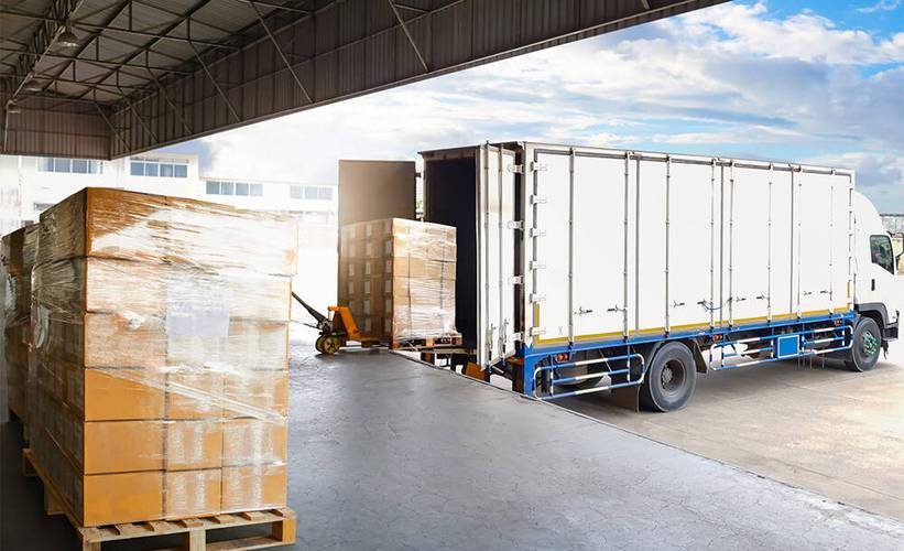 Palletized freight being loaded from a warehouse dock into a truck