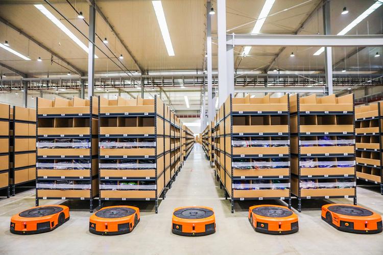 Organized warehouse shelving with mobile handling equipment